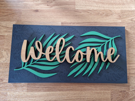Decorative doormat with 'Welcome' and leaf designs on a wooden floor.